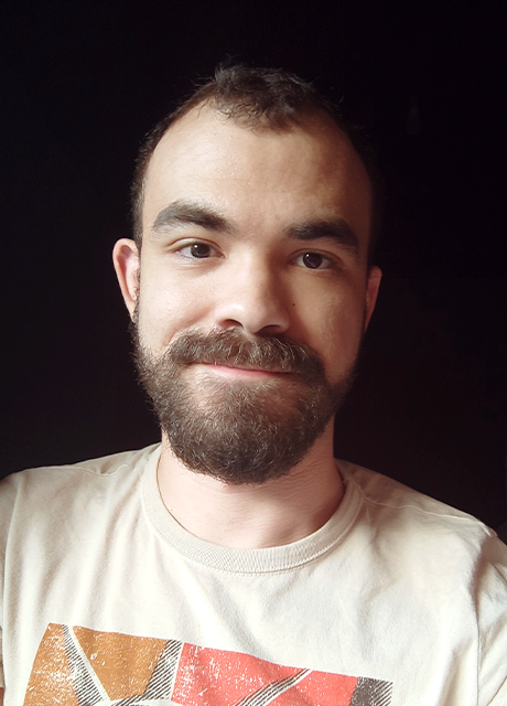 A selfie of me with a pitch-black background. Not sure whether I'm smiling or not.